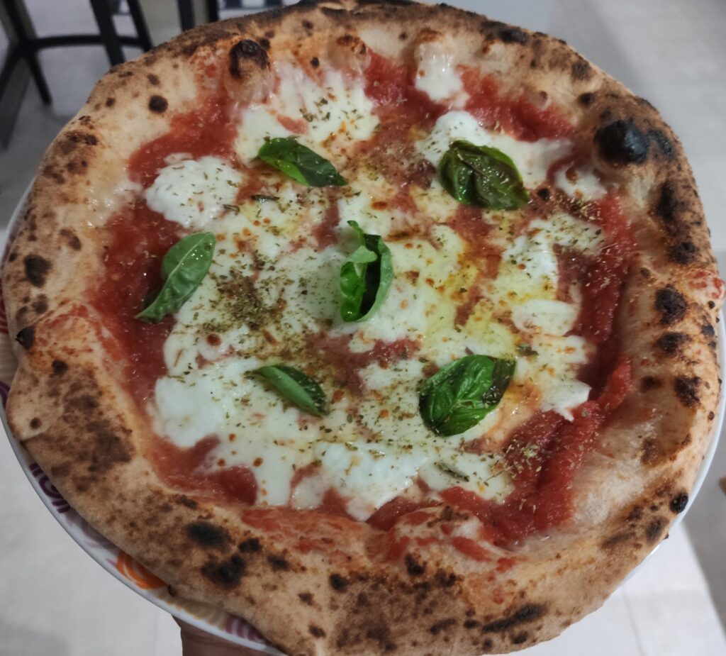 Pizza Margherita fatta con le dosi del disciplinare STG, appena sfornata, con il cornicione maculato